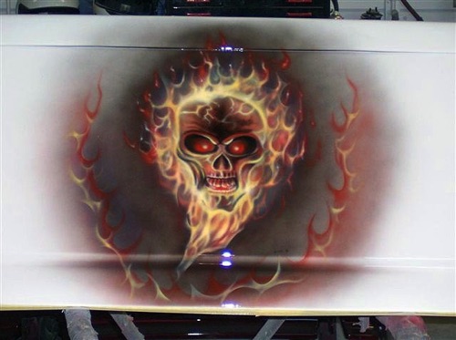 A flaming skull on the tail gate of a pickup truck.